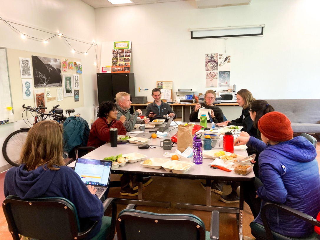 Outer Coast staff laugh around a table